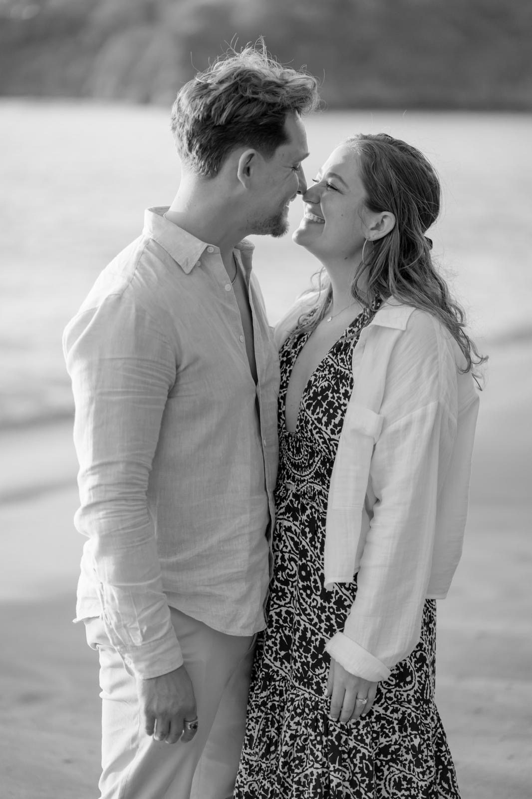 Black and white photo of Shelby and Andy nose to nose on a beach